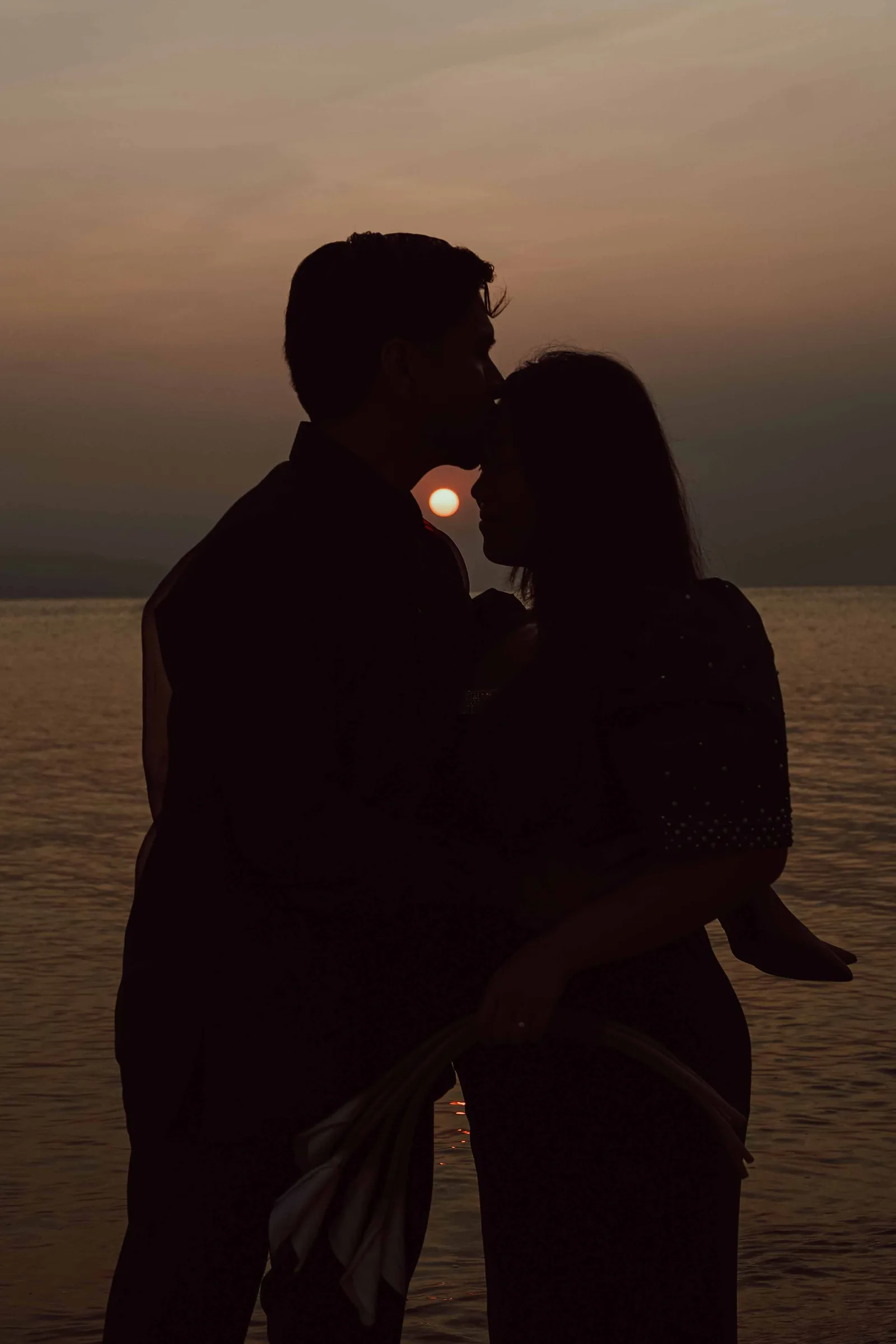 Intimate silhouette of couple at dusk by the water — wedding photography by Vivid Visuals