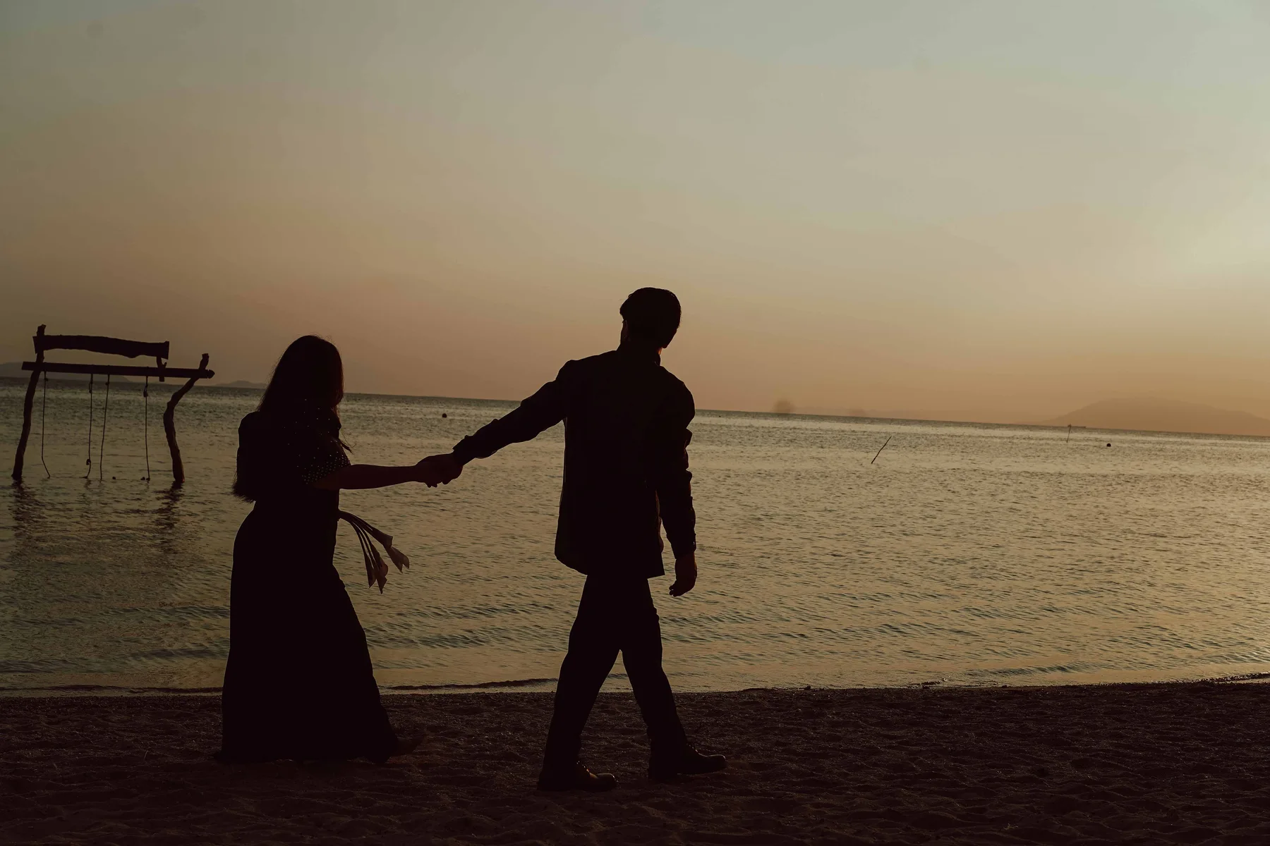 Couple hand in hand walking into the sunset over the sea — luxury wedding photography Philippines, Vivid Visuals