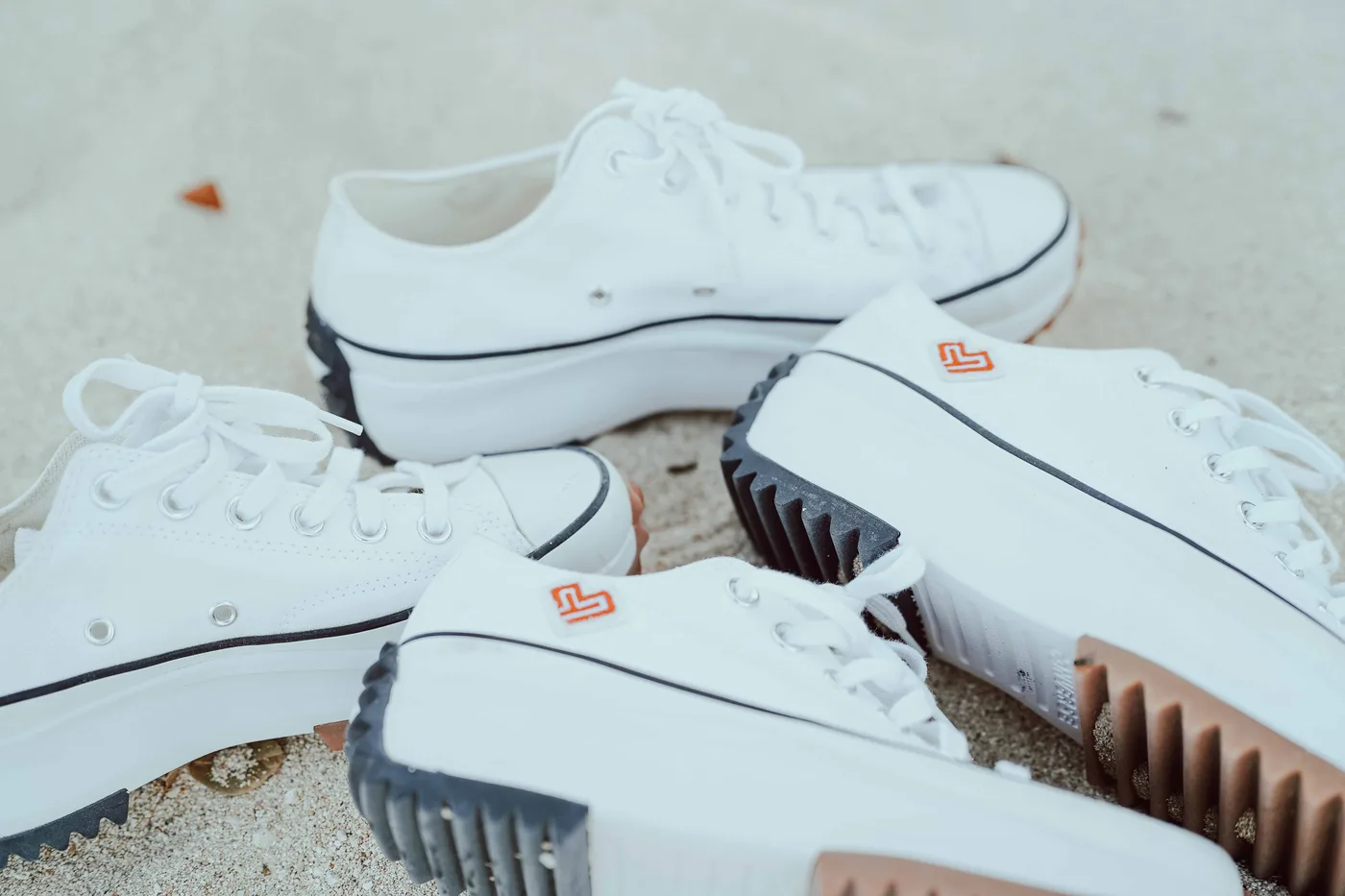 Matching white sneakers detail at a beach engagement session — Vivid Visuals